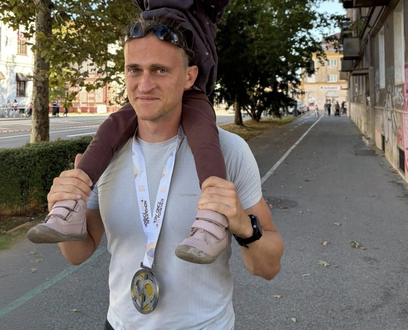 Michal Kováč s dcérou na pleciach a medailou z Košického maratónu